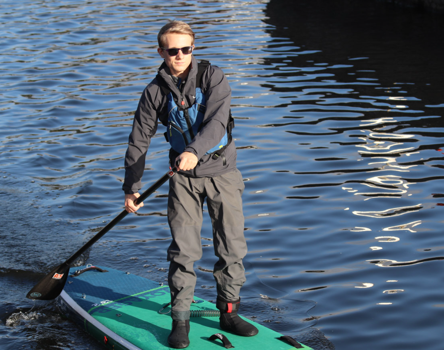 a man standing next to a body of water