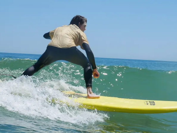 A teenager catches a wave on a surfboard rental near Long Beach Island, NJ.