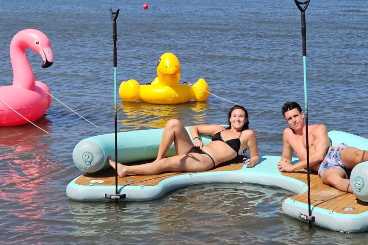 a woman sitting next to a body of water