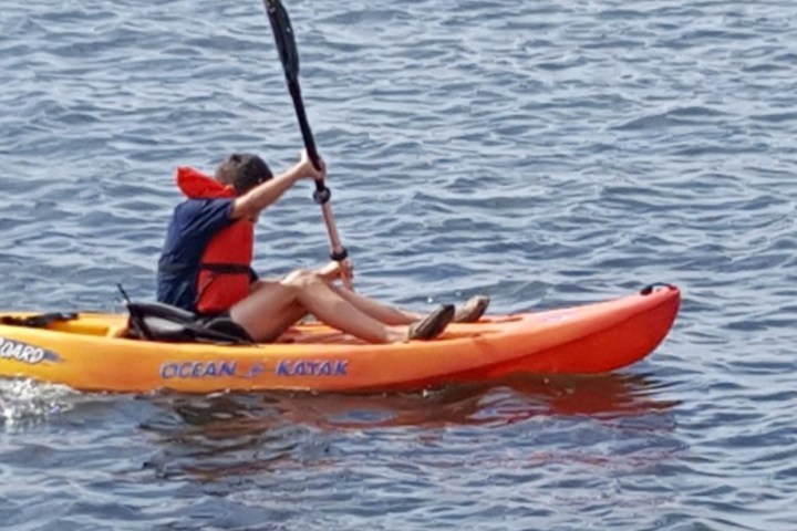 a man riding on the back of a boat in a body of water