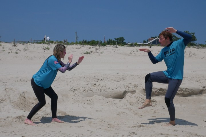 a man and a woman playing a game of frisbee on a beach