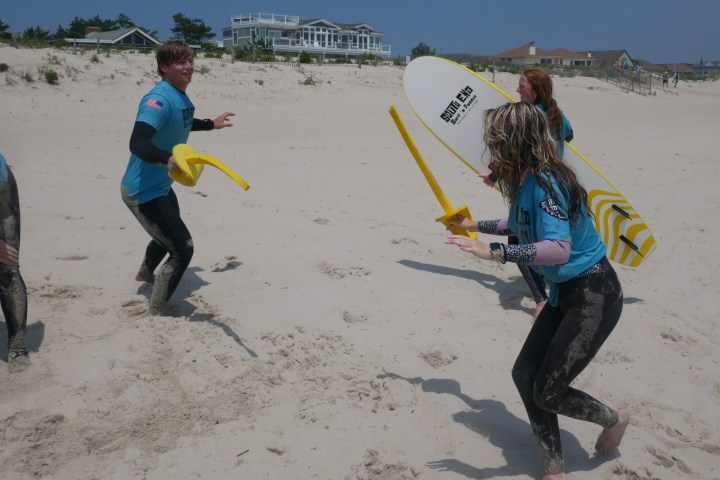 a couple of people that are standing in the sand on a beach