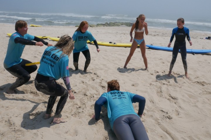 a group of people standing on top of a sandy beach