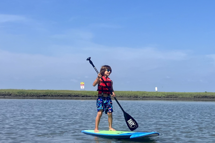 a man riding on the back of a boat in a body of water