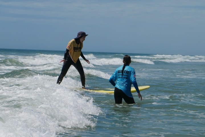 a man riding a wave on a surf board on a body of water