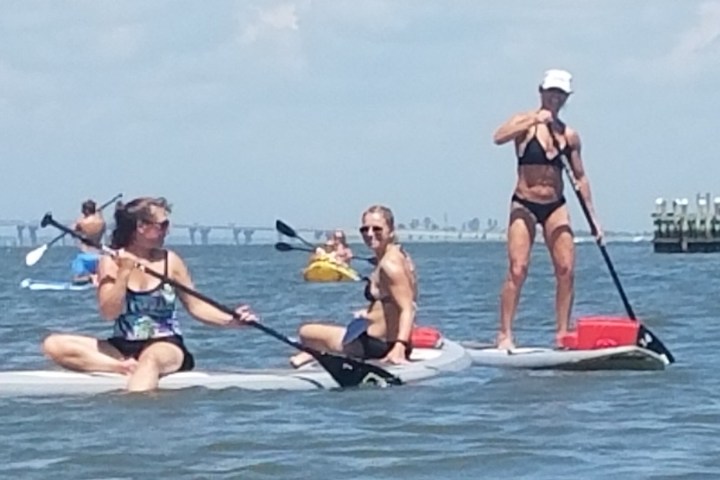 a group of people riding on the back of a boat in the water