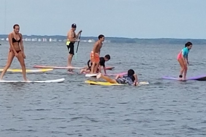 a group of people standing next to a body of water