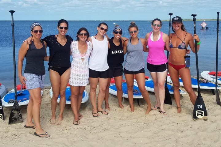 a group of people standing on a beach posing for the camera