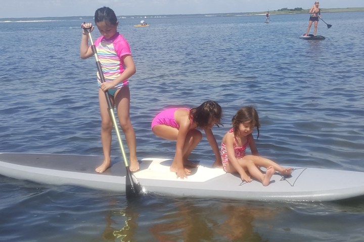 a young girl riding a wave on a surfboard in the water