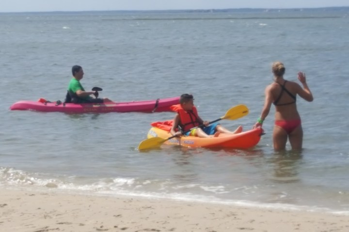 a group of people in a boat on the beach