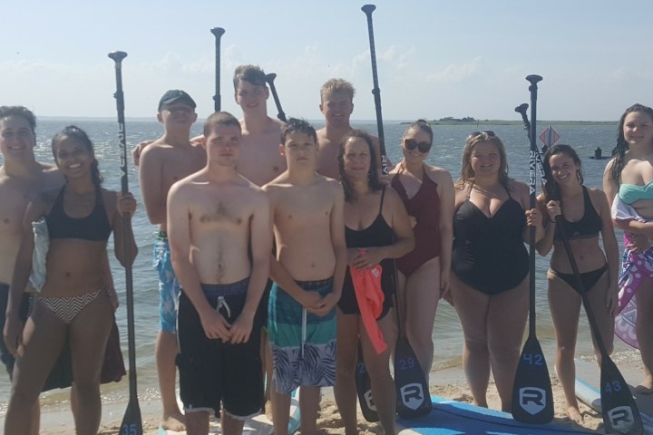 a group of people standing on a beach posing for the camera