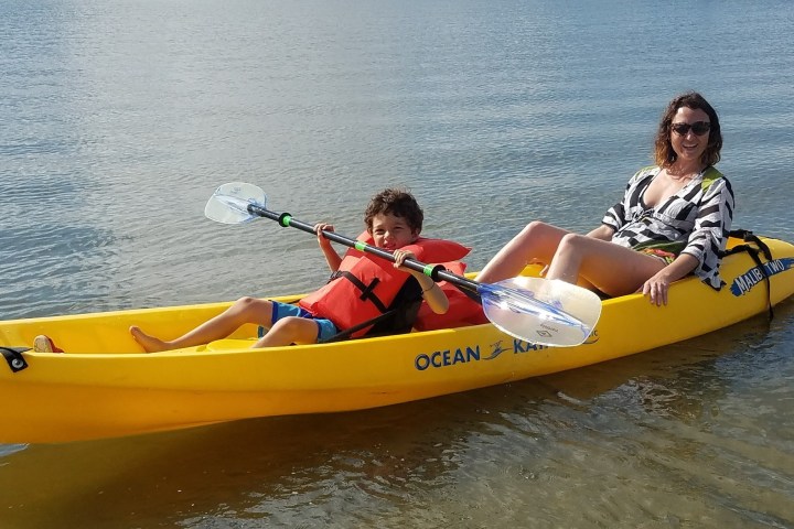 a person riding on the back of a boat on a body of water