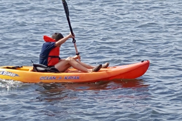 a man riding on the back of a boat in a body of water