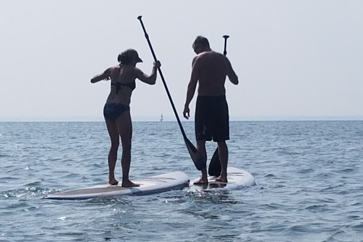 a man standing next to a body of water