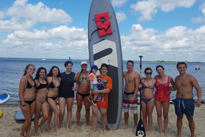 a group of people standing on a beach posing for the camera
