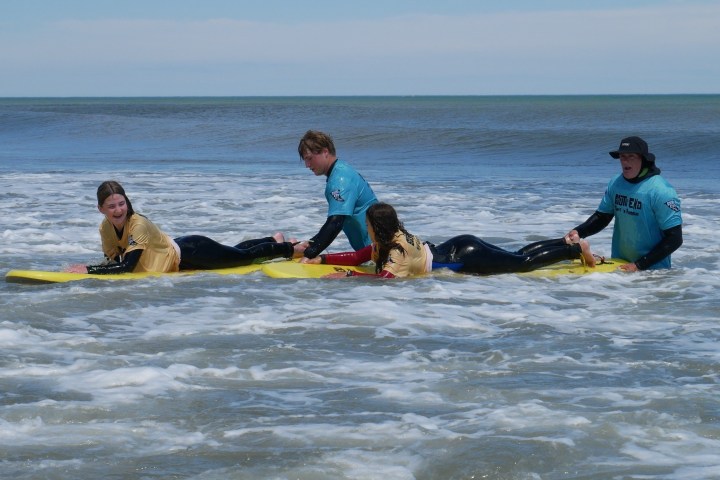 a couple of people that are lying next to a body of water