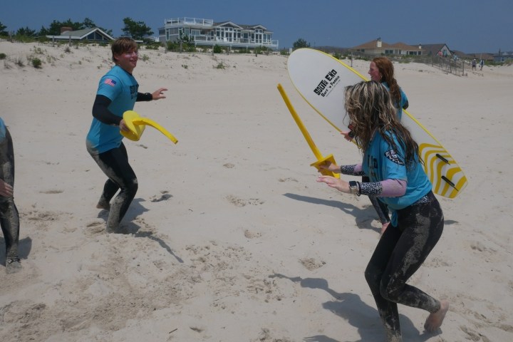a couple of people that are standing in the sand on a beach