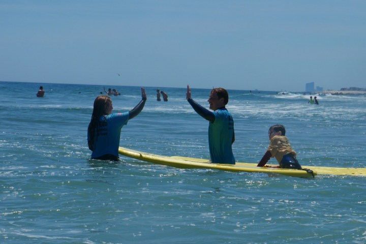 a group of people riding on the back of a boat in the water