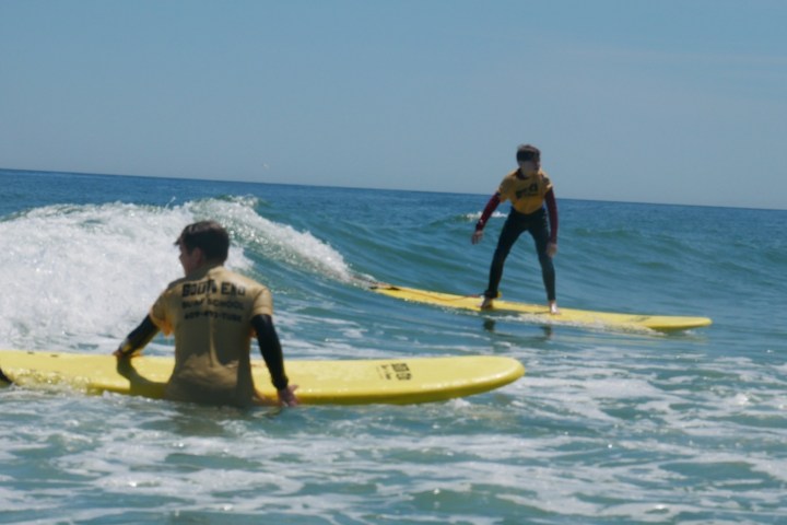 a young girl riding a wave on a surfboard in the ocean