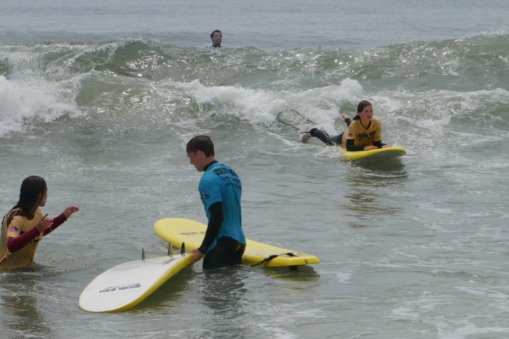 a young girl riding a wave on a surfboard in the water