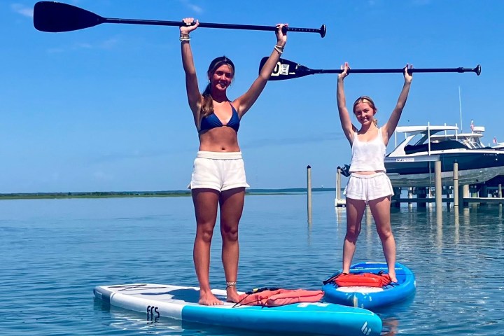 a woman standing next to a body of water