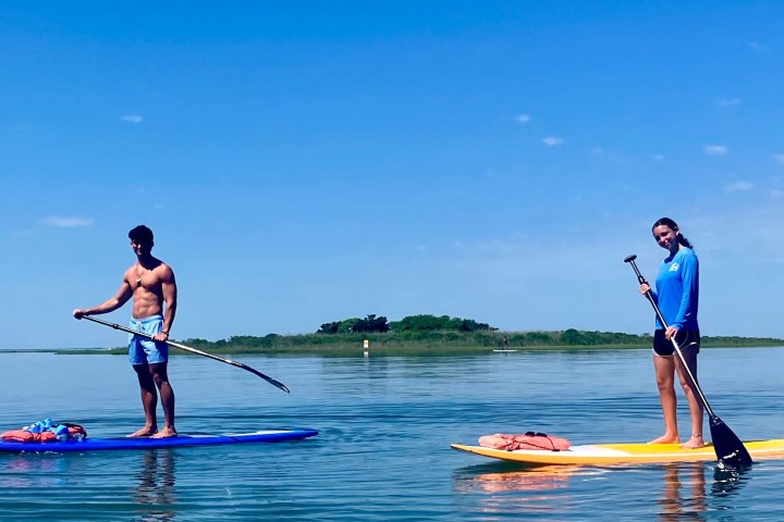 a group of people riding on the back of a boat in the water