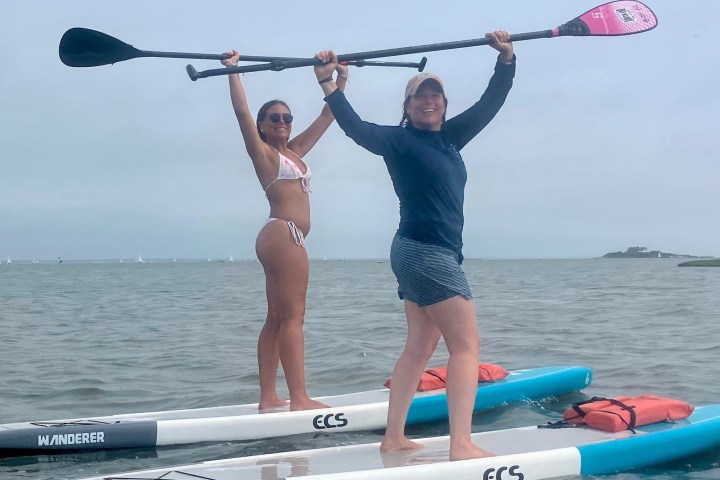 a woman standing next to a body of water