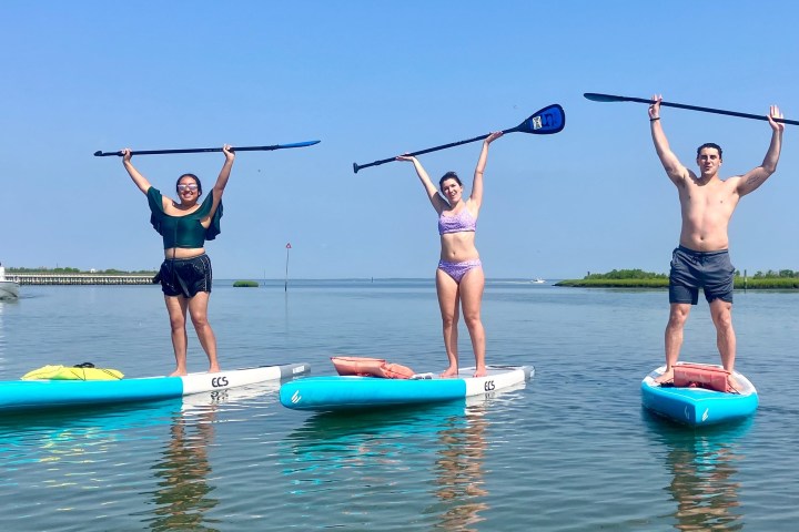 a group of people riding on the back of a boat in the water