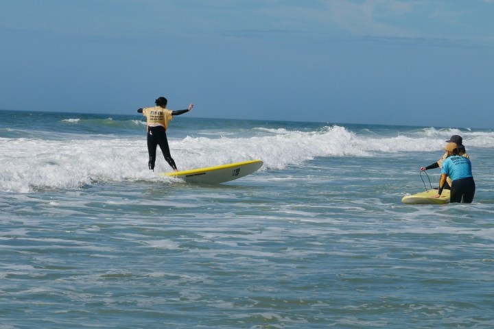 a man riding a wave on a surf board on a body of water