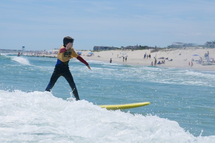 a man riding a wave on a surf board on a body of water