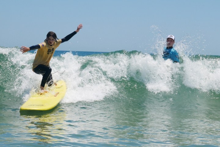 a young girl riding a wave on a surfboard in the ocean