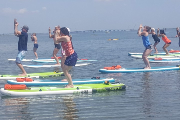 a group of people standing next to a body of water