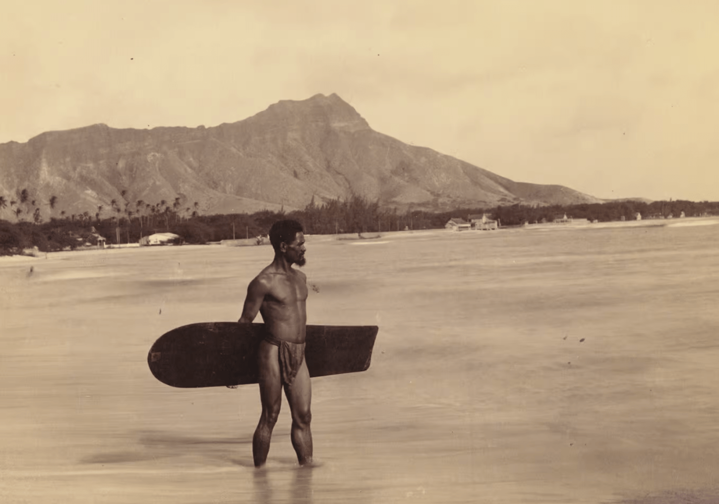 a person carrying a surfboard on top of a mountain