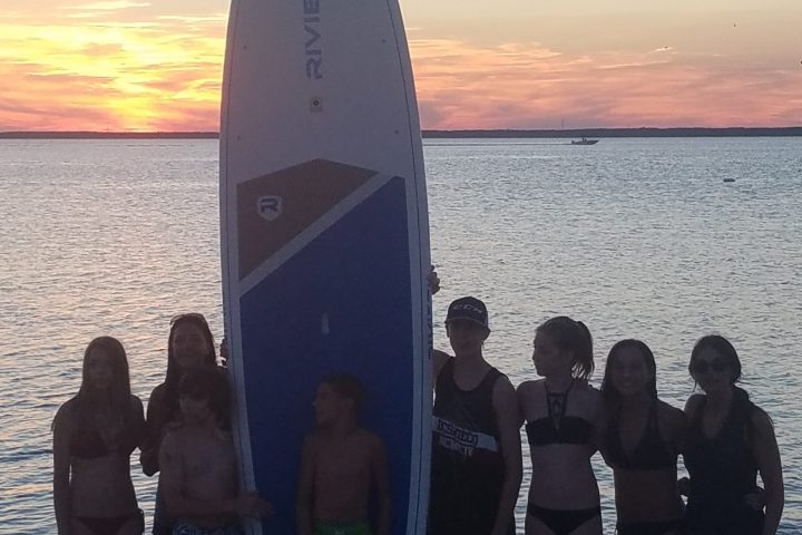 a group of people standing on a beach posing for the camera