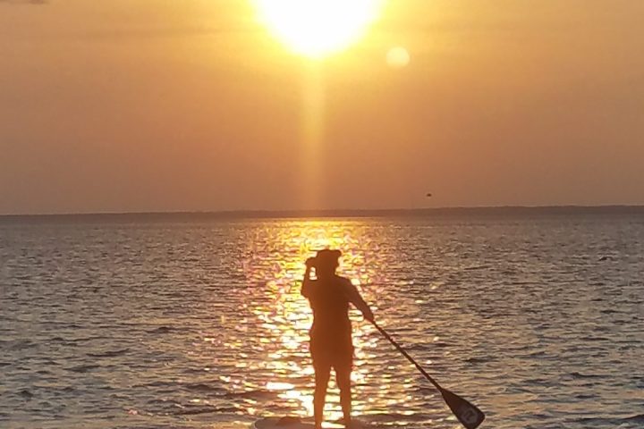 a man standing next to a body of water