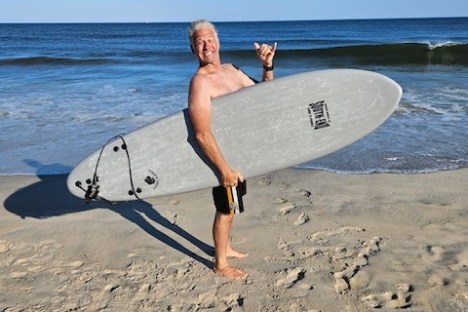 a man carrying a surf board on a beach